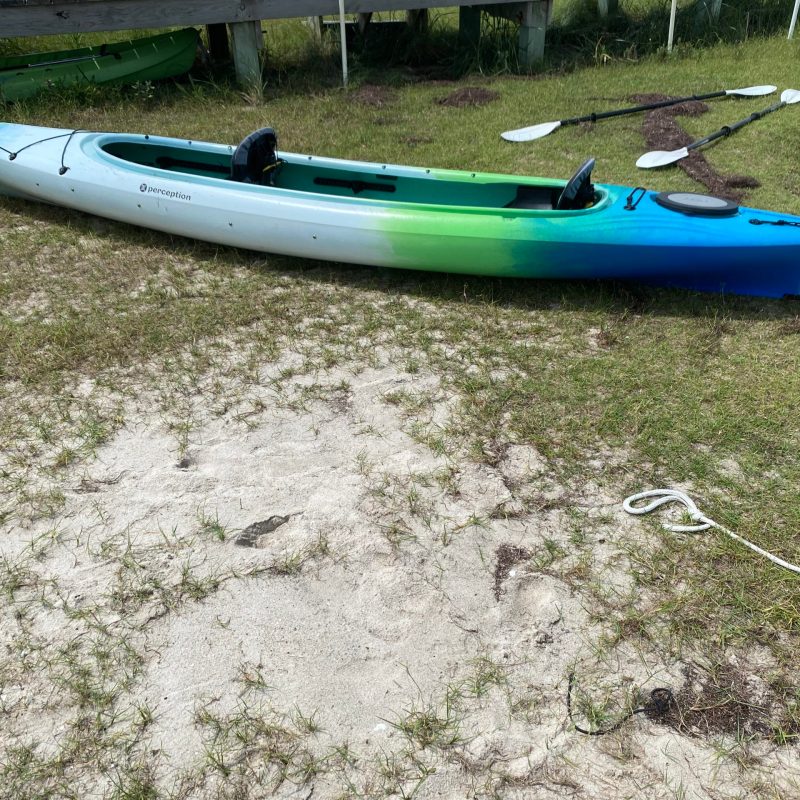 tandem kayak sitting on the shore